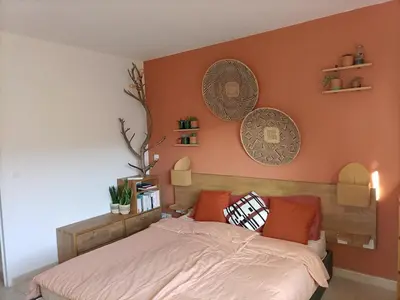 a bedroom with a bed with orange walls at T2 lumineux balcon, parking facile, climatisation, Wi-Fi in Aix-en-Provence