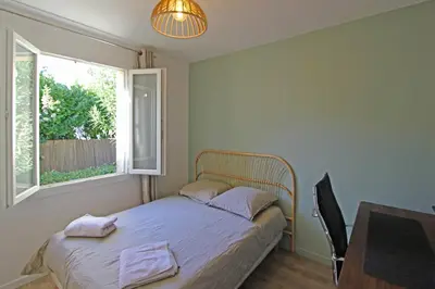 a bedroom with a bed and a desk and a window at Havre de paix avec piscine & spa - proche Ventoux in Saint-Didier