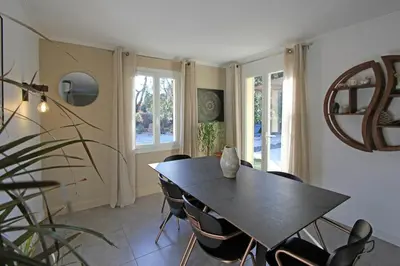 a dining room with a black table and chairs at Havre de paix avec piscine & spa - proche Ventoux in Saint-Didier