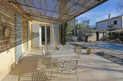 a patio with a table and chairs on a patio at Havre de paix avec piscine & spa - proche Ventoux in Saint-Didier