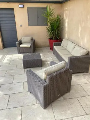 a patio with wicker chairs and couches on a patio at Villa avec vue au pied du Luberon in Maubec