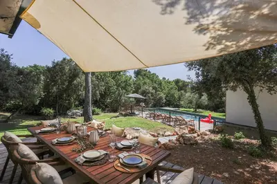 a wooden table with an umbrella on a patio at Bali Style, Chic & Big Villa - Peaceful and Calm in Saint-Marc-Jaumegarde