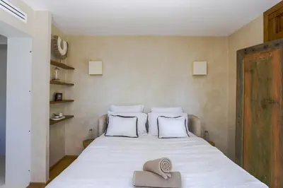 a bed with two pillows and a hat on it at Bali Style, Chic & Big Villa - Peaceful and Calm in Saint-Marc-Jaumegarde
