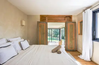 a bedroom with a large white bed and a window at Bali Style, Chic & Big Villa - Peaceful and Calm in Saint-Marc-Jaumegarde