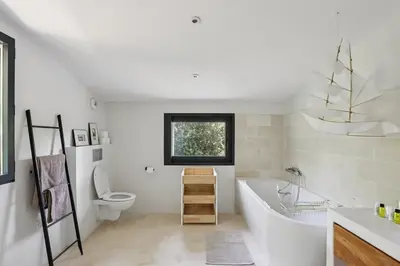 a white bathroom with a tub and a toilet at Bali Style, Chic & Big Villa - Peaceful and Calm in Saint-Marc-Jaumegarde