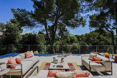 a patio with couches and tables and a tree at Bali Style, Chic & Big Villa - Peaceful and Calm in Saint-Marc-Jaumegarde