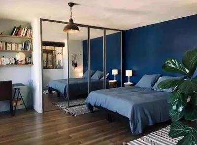 a bedroom with a bed and a blue wall at Grand appartement avec terrasse place Richelme in Aix-en-Provence