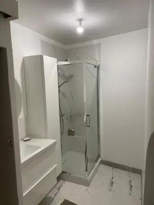 a white bathroom with a shower and a sink at plaisir de vacances in Aix-en-Provence