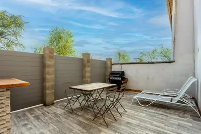 a balcony with a table and chairs and a grill at L'Oustaou - Climatisé avec terrasse in Pélissanne