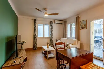 a living room with a tv and a table at L'Oustaou - Climatisé avec terrasse in Pélissanne