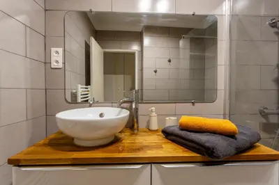 a bathroom with a sink and a mirror at L'Oustaou - Climatisé avec terrasse in Pélissanne