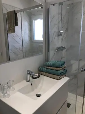a white bathroom with a sink and a shower at La Cigale et la Fourmi in Les Taillades