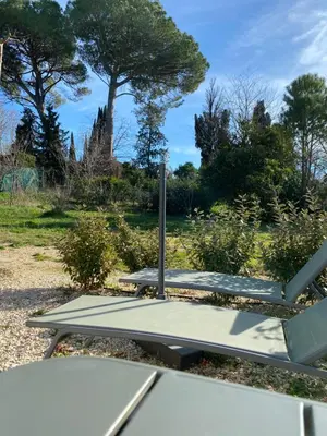 a picnic table in a park with trees in the background at La Cigale et la Fourmi in Les Taillades