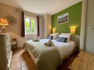 a bedroom with a large bed with green walls at Jolie maison avec piscine à Gordes in Gordes