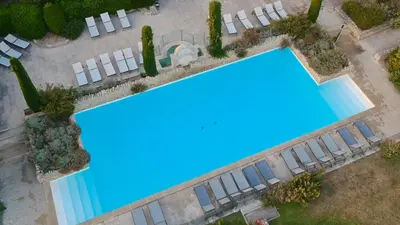 an overhead view of a swimming pool with white chairs at Jolie maison avec piscine à Gordes in Gordes