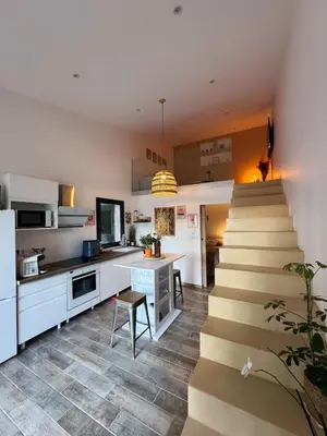 a kitchen with a staircase leading up to a kitchen at COZY LOFT - Maisonnette esprit loft in Saint-Cannat