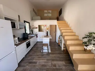 a staircase in a small kitchen with a table and a counter at COZY LOFT - Maisonnette esprit loft in Saint-Cannat