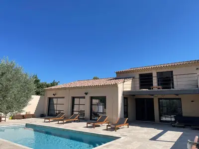 a house with a swimming pool in front of a house at Villa contemporaine avec piscine - 5 min de Gordes - vue sur le Luberon in Cabrières-dʼAvignon