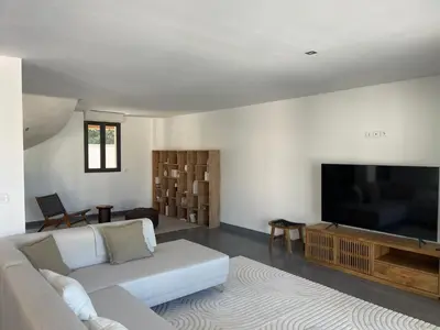 a living room with a couch and a flat screen tv at Villa contemporaine avec piscine - 5 min de Gordes - vue sur le Luberon in Cabrières-dʼAvignon