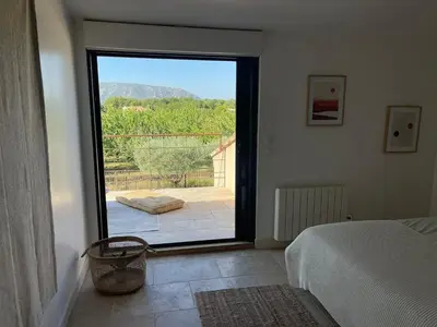 a bedroom with a bed and a large sliding glass door at Villa contemporaine avec piscine - 5 min de Gordes - vue sur le Luberon in Cabrières-dʼAvignon