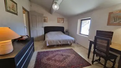 a bedroom with a bed and a desk and a table at La Fabrique in Gargas