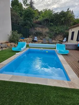 a swimming pool with blue chairs in a yard at Villa situé à Sainte-Tulle in Sainte-Tulle