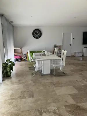 a living room with a table and chairs and a clock at Villa situé à Sainte-Tulle in Sainte-Tulle