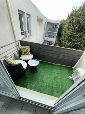 a balcony with a table and chairs on a building at Appartement en résidence privé Avignon Agroparc in Avignon