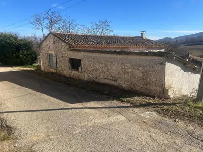 an old stone building on the side of a road at Jolie maison au coeur du Luberon in Saint-Martin-de-Castillon