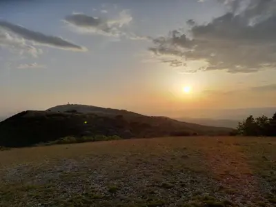a sunset on top of a hill with the sun setting at Jolie maison au coeur du Luberon in Saint-Martin-de-Castillon