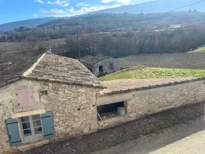 an old stone building with a window and a hill at Jolie maison au coeur du Luberon in Saint-Martin-de-Castillon