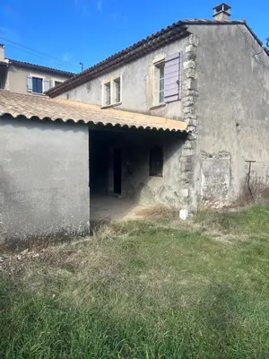 an old stone house with a grassy yard in front of it at Jolie maison au coeur du Luberon in Saint-Martin-de-Castillon