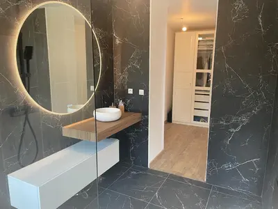 a bathroom with a round mirror and a sink at Villa moderne tout confort in Salon-de-Provence