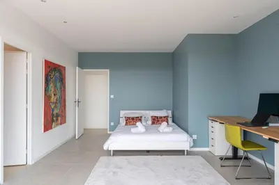 a bedroom with a bed and a desk with a computer at Elynéa - Vue panoramique - Haut standing - Piscine in Rognes