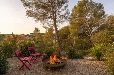two red chairs sitting next to a fire pit at Elynéa - Vue panoramique - Haut standing - Piscine in Rognes