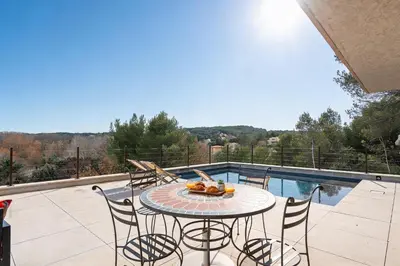 a patio with a table and chairs and a pool at Elynéa - Vue panoramique - Haut standing - Piscine in Rognes