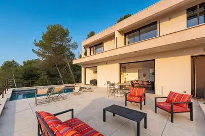 a patio with chairs and a table and a pool at Elynéa - Vue panoramique - Haut standing - Piscine in Rognes