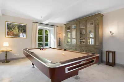 a room with a pool table in a room with a window at La Bastide des Plâtrières in La Roque-sur-Pernes
