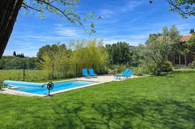 a swimming pool in front of a house at Havre de paix avec piscine au pied du Ventoux in Caromb