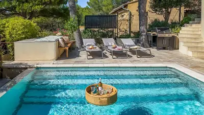a swimming pool with a boat in the water at Mas Noves - Horizon Alpilles villa in Noves