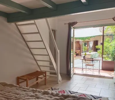a bedroom with a staircase leading to a patio at Maison Maïtri in Lauris