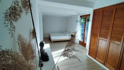 a room with a bedroom with a bed and a mirror at Maison Maïtri in Lauris