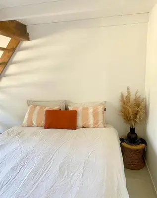 a white bed with two pillows on top of it at Maison Maïtri in Lauris