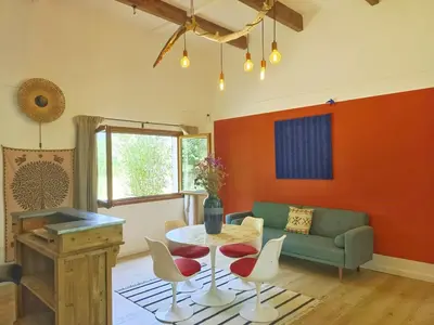 a living room with a couch and a table and chairs at Maison Maïtri in Lauris