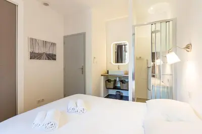 a bedroom with a white bed with towels on it at Appartement centre ville, Air Conditionné, 2 suites, parking sur demande in Aix-en-Provence