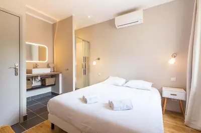 a bedroom with a white bed and a bathroom at Appartement centre ville, Air Conditionné, 2 suites, parking sur demande in Aix-en-Provence