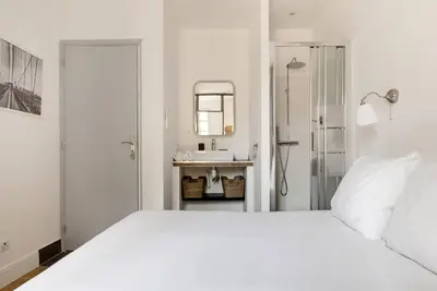 a white bedroom with a white bed and a sink at Appartement centre ville, Air Conditionné, 2 suites, parking sur demande in Aix-en-Provence