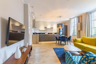 a living room with a yellow couch and a table at Appartement centre ville, Air Conditionné, 2 suites, parking sur demande in Aix-en-Provence