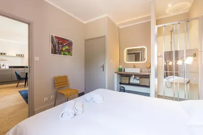 a bedroom with a white bed and a bathroom at Appartement centre ville, Air Conditionné, 2 suites, parking sur demande in Aix-en-Provence