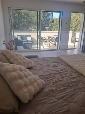 a bedroom with a large bed with a view of a patio at Le Nid in Châteaurenard